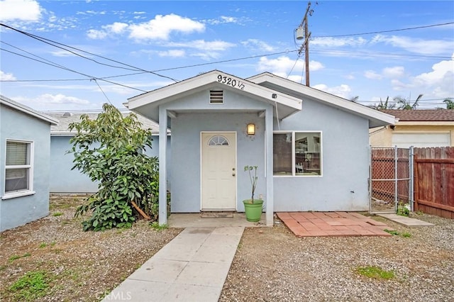 view of front of house with fence and stucco siding