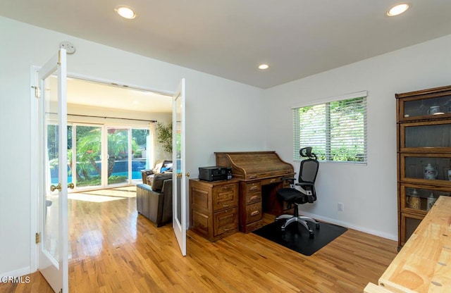 office space featuring baseboards, light wood-type flooring, and recessed lighting