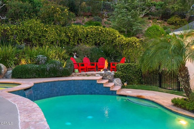 pool with a patio area and fence