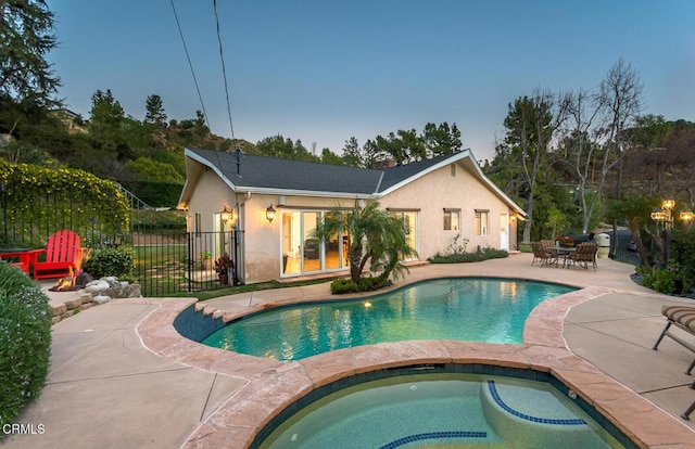 view of swimming pool featuring a fenced in pool, a patio, fence, and an in ground hot tub