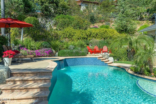 outdoor pool with a patio and fence