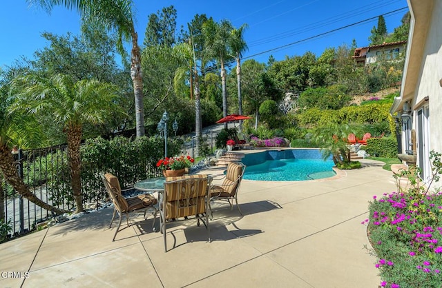 outdoor pool with outdoor dining area, a patio, and fence