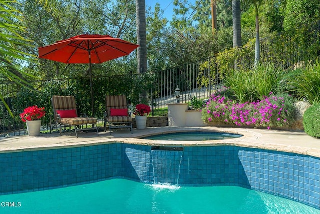 outdoor pool featuring an in ground hot tub and fence