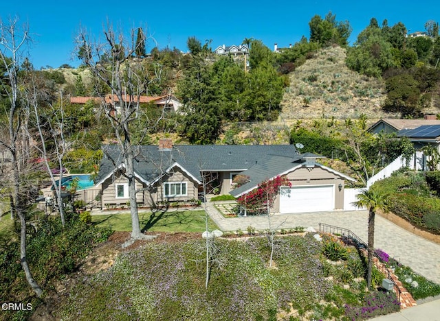 view of front of house featuring a front lawn, decorative driveway, and an attached garage