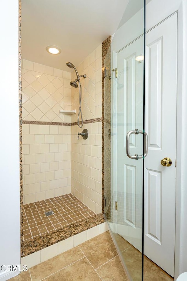 bathroom with tile patterned flooring and a shower stall