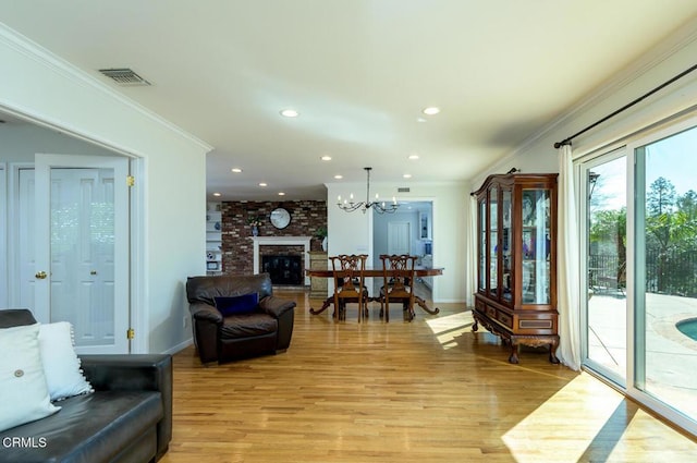 living room with light wood finished floors, recessed lighting, visible vents, and ornamental molding