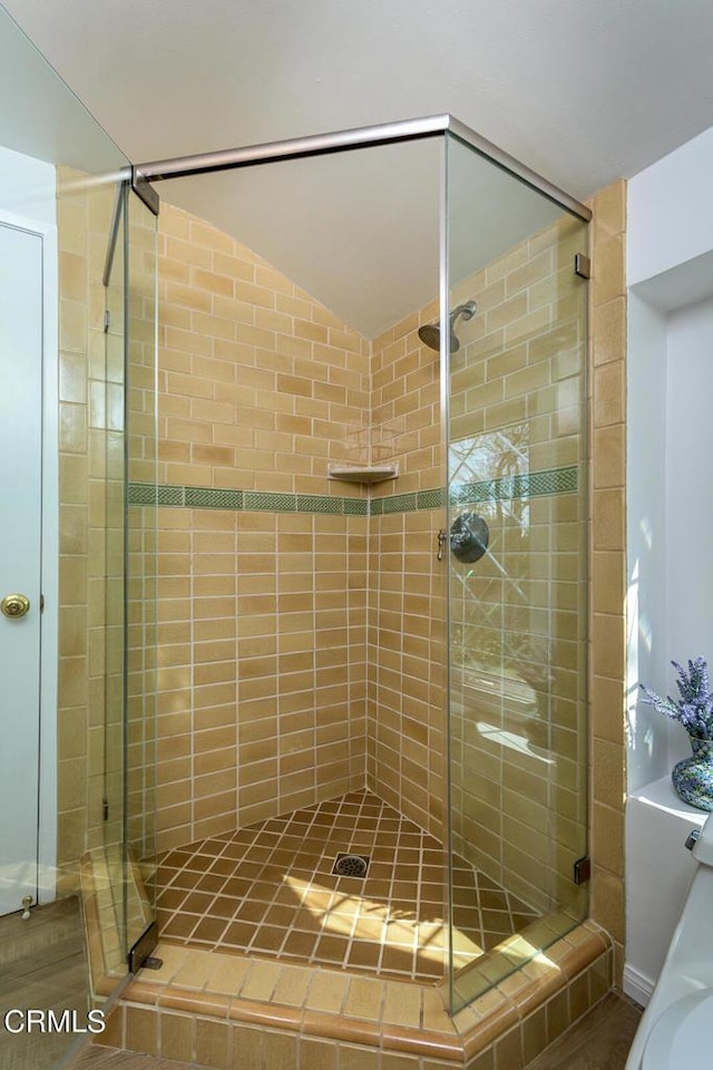 full bath with lofted ceiling and a stall shower