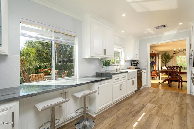 kitchen with dishwasher, light wood finished floors, visible vents, and white cabinets