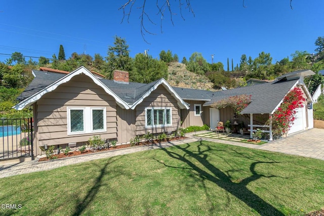 ranch-style house with a chimney, roof with shingles, an attached garage, fence, and a front yard