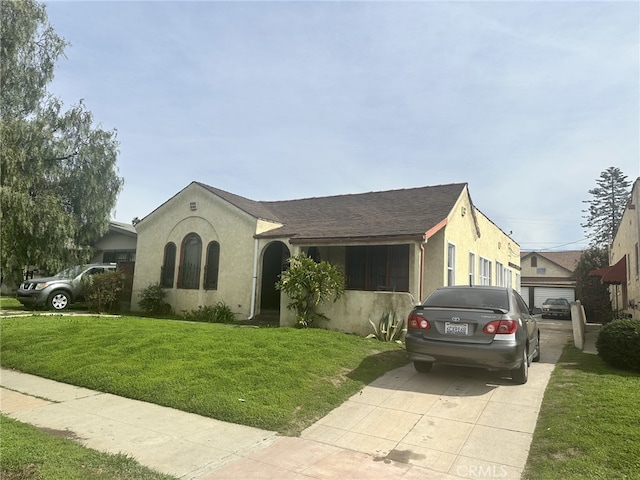 view of front facade with a front yard and stucco siding