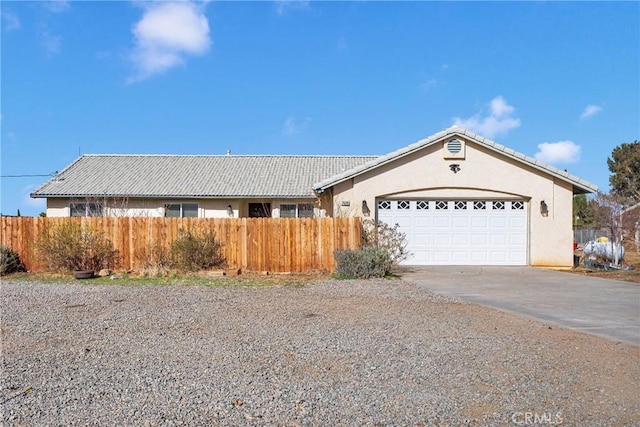 ranch-style house with a garage, a tile roof, fence, concrete driveway, and stucco siding