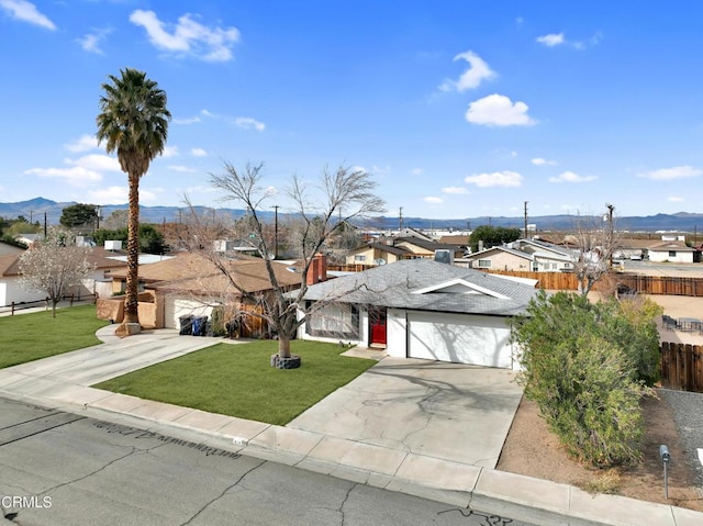 ranch-style home featuring an attached garage, fence, concrete driveway, a residential view, and a front yard