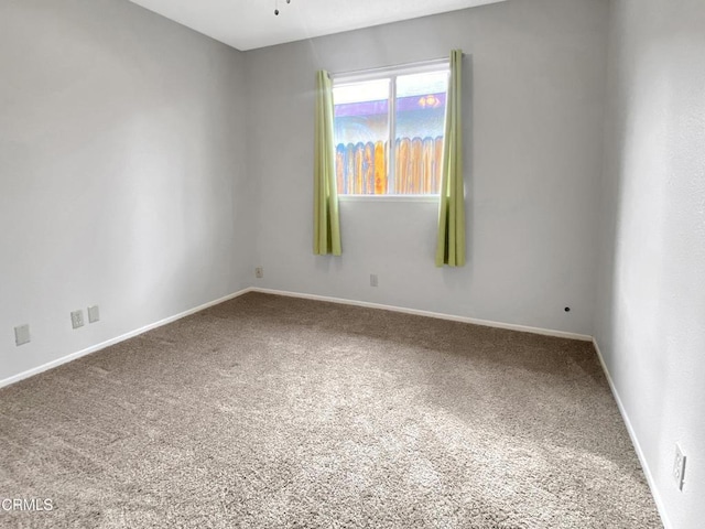 unfurnished room with carpet floors and baseboards