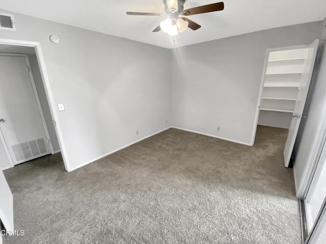 unfurnished bedroom with carpet floors, baseboards, a spacious closet, and visible vents