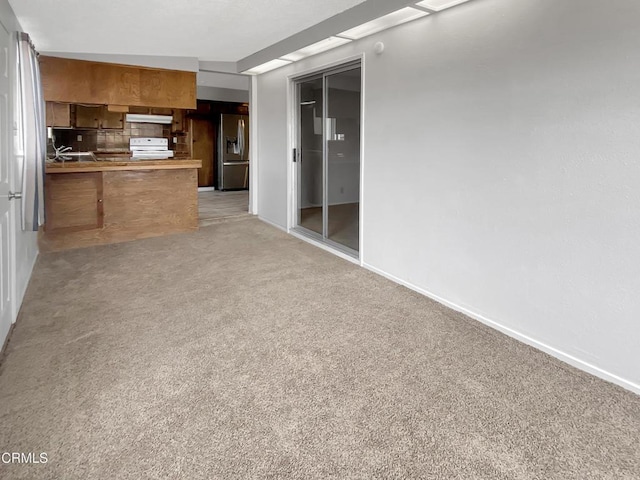 interior space with under cabinet range hood, light colored carpet, white electric range, open floor plan, and stainless steel fridge with ice dispenser