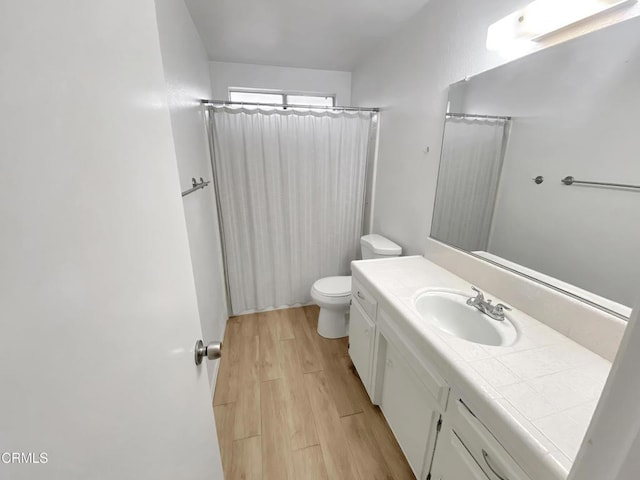 full bath featuring toilet, curtained shower, wood finished floors, and vanity