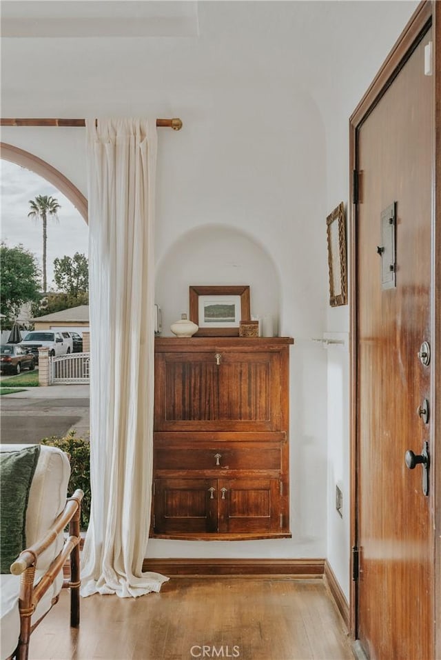 corridor featuring wood finished floors and baseboards