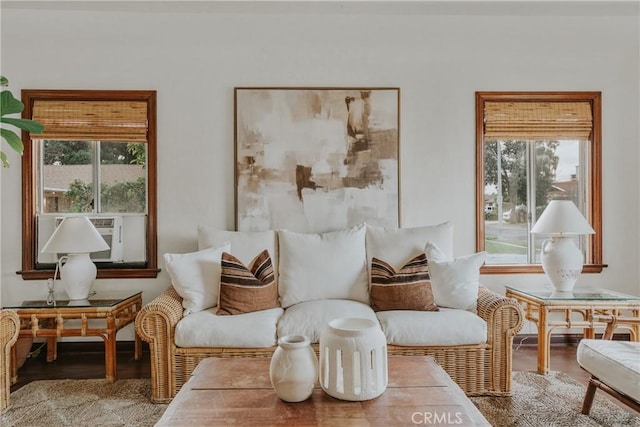 living area featuring plenty of natural light, cooling unit, and wood finished floors