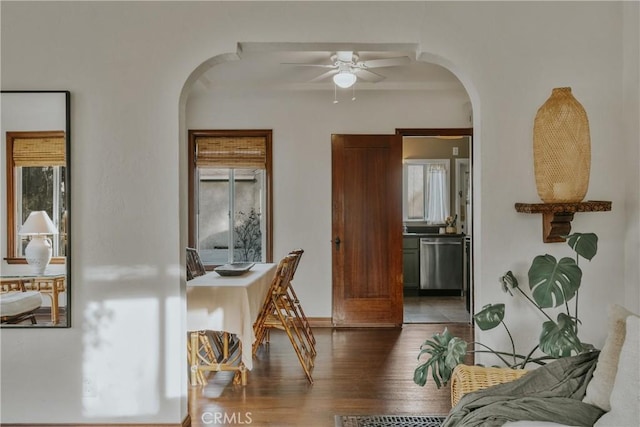 interior space with arched walkways and wood finished floors