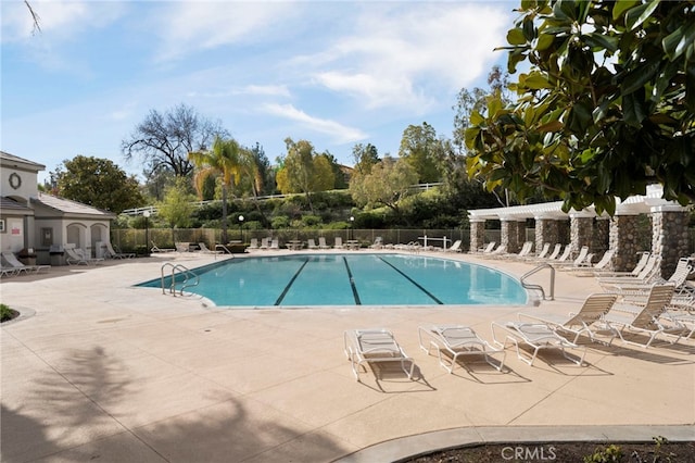 pool featuring a patio area and fence