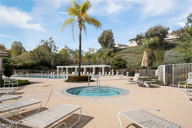 community pool featuring fence and a patio