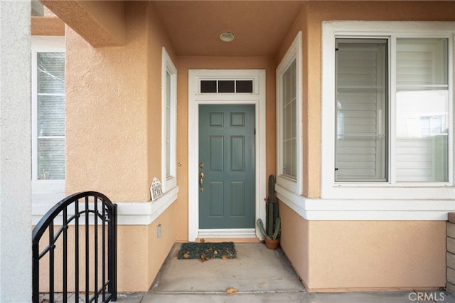 doorway to property featuring stucco siding