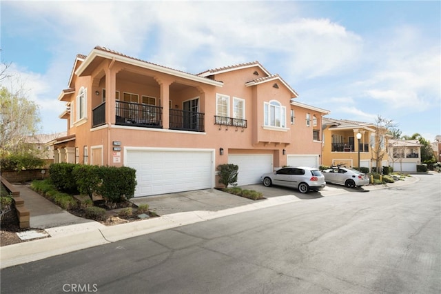 view of front of property with an attached garage, concrete driveway, and stucco siding