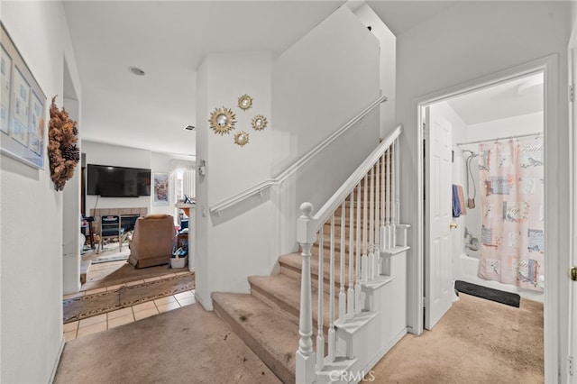 stairway with tile patterned flooring and carpet flooring