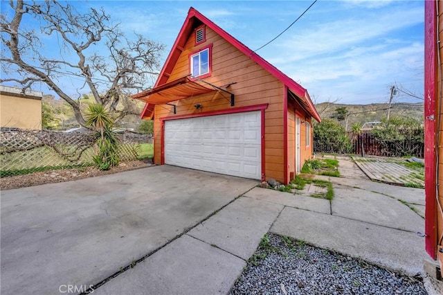 detached garage featuring fence