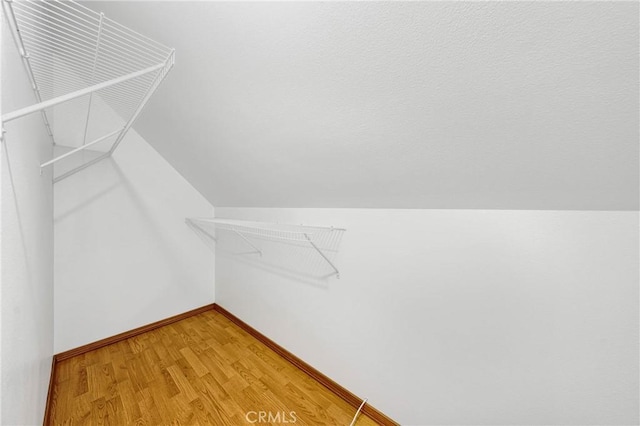 walk in closet featuring lofted ceiling and light wood finished floors