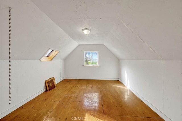 bonus room with lofted ceiling and hardwood / wood-style floors