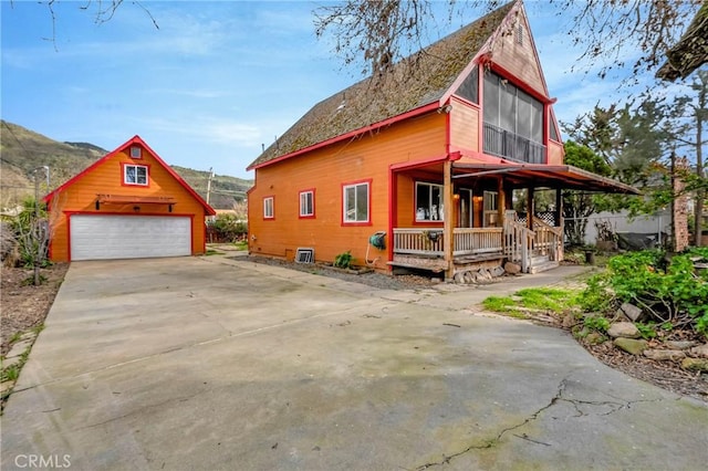 view of property exterior featuring a garage, a porch, and an outdoor structure