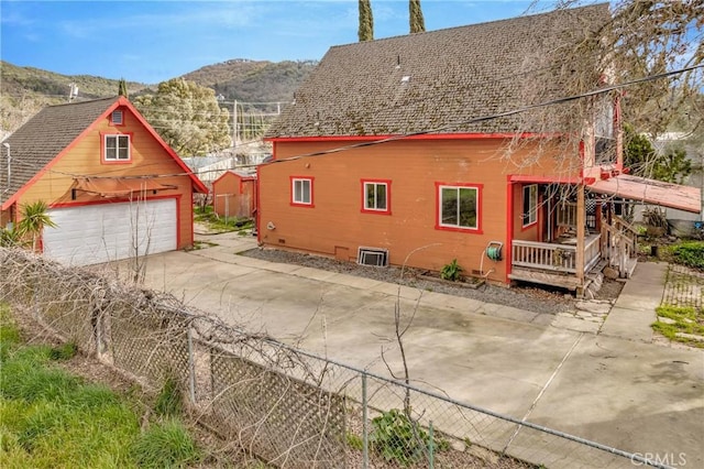 view of home's exterior featuring a garage, a shingled roof, fence, and a mountain view