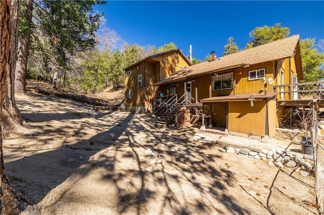 back of property featuring roof with shingles