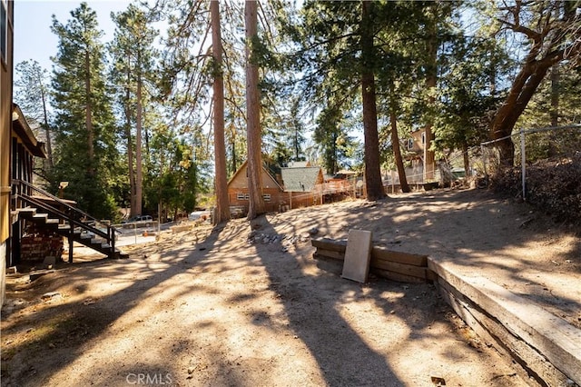 view of yard featuring fence and stairway