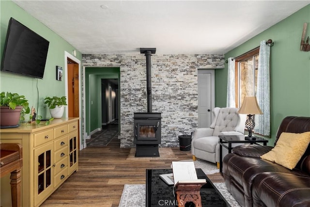 living area with a wood stove and dark wood-style flooring