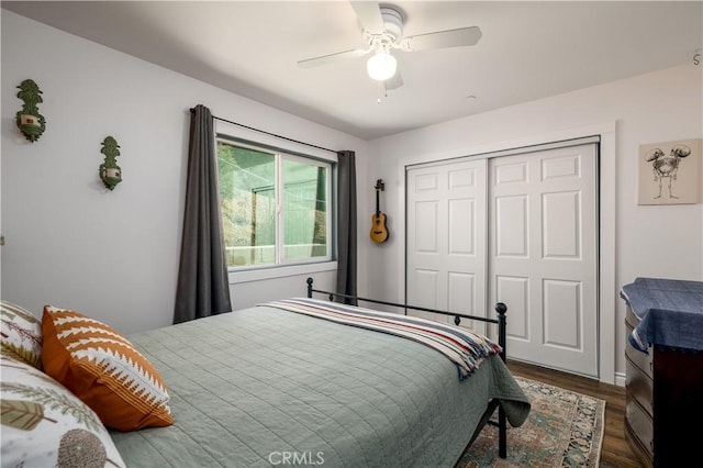 bedroom with a ceiling fan, dark wood-style flooring, and a closet