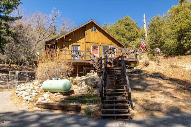 chalet / cabin featuring fence, stairway, and a deck