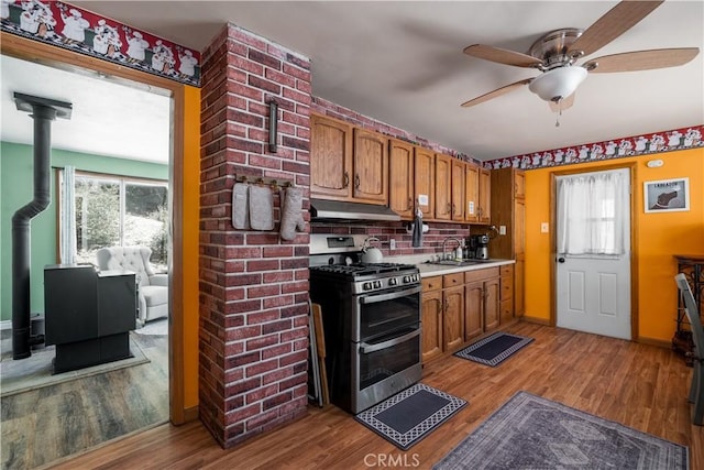 kitchen with a wood stove, plenty of natural light, double oven range, and light countertops