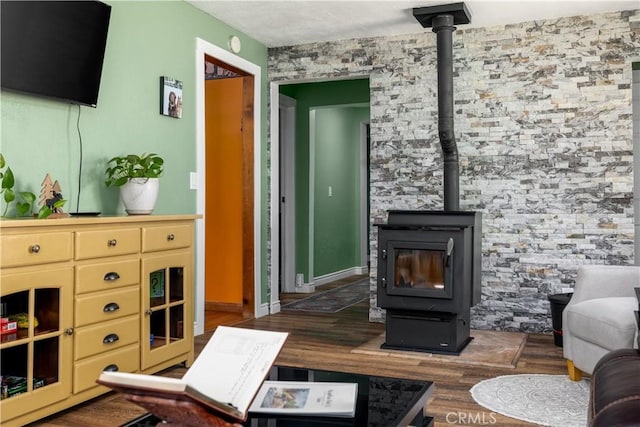 living area featuring a wood stove and wood finished floors