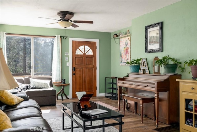 interior space featuring ceiling fan, baseboards, and wood finished floors