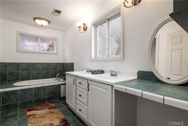 bathroom with tile patterned flooring, visible vents, a sink, and double vanity