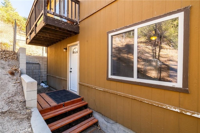 property entrance with fence and a balcony