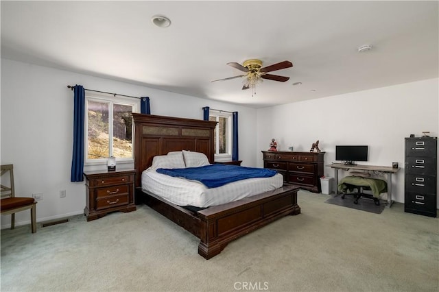 bedroom featuring a ceiling fan, light carpet, visible vents, and baseboards