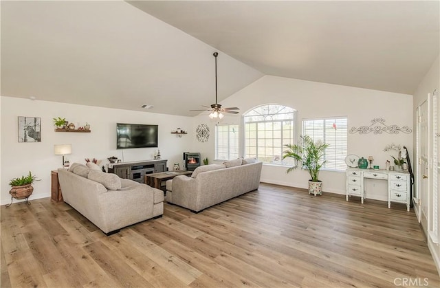 47384 Veater Ranch Rd, Coarsegold, CA 93614 - living area featuring ceiling fan, light wood finished floors, a glass covered fireplace, high vaulted ceiling, and baseboards