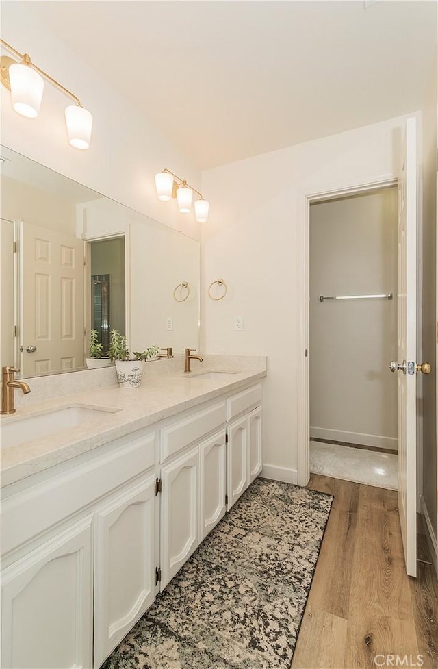 47384 Veater Ranch Rd, Coarsegold, CA 93614 - bathroom with double vanity, wood finished floors, and baseboards