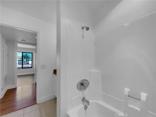 bathroom with shower / bathtub combination, baseboards, and tile patterned floors