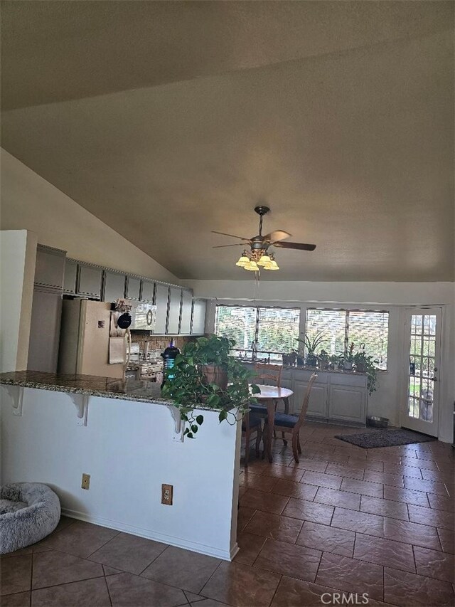 27865 Quincy St, Castaic, CA 91384 - kitchen featuring refrigerator, a breakfast bar area, ceiling fan, plenty of natural light, and vaulted ceiling