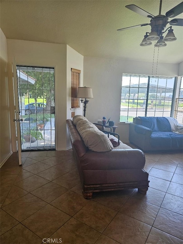 27865 Quincy St, Castaic, CA 91384 - living room with ceiling fan, healthy amount of natural light, dark tile patterned floors, and a textured ceiling