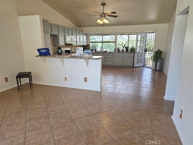 27865 Quincy St, Castaic, CA 91384 - kitchen with gray cabinets, lofted ceiling, a peninsula, a ceiling fan, and stone countertops
